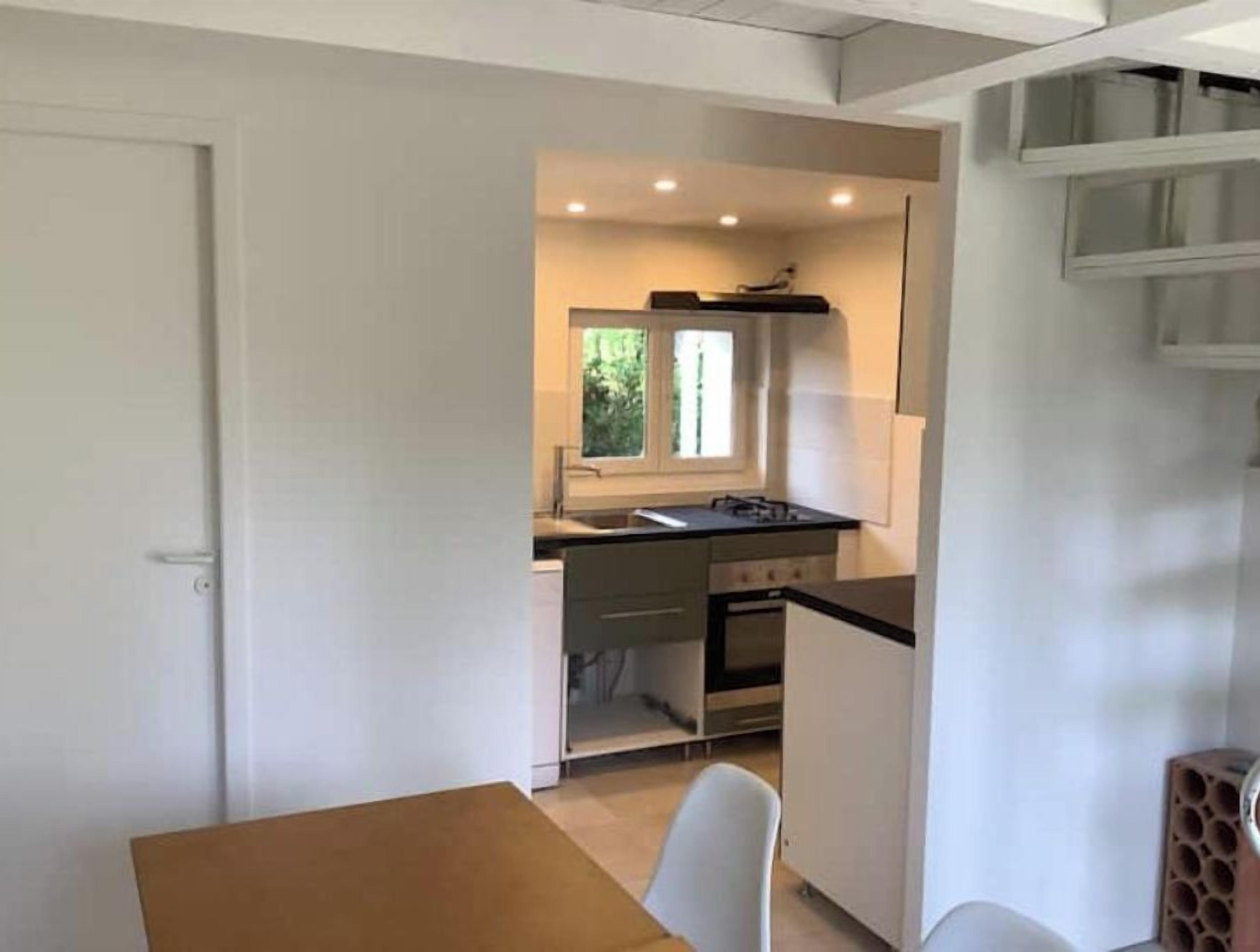 A compact kitchen with a window, a stove, and a sink.