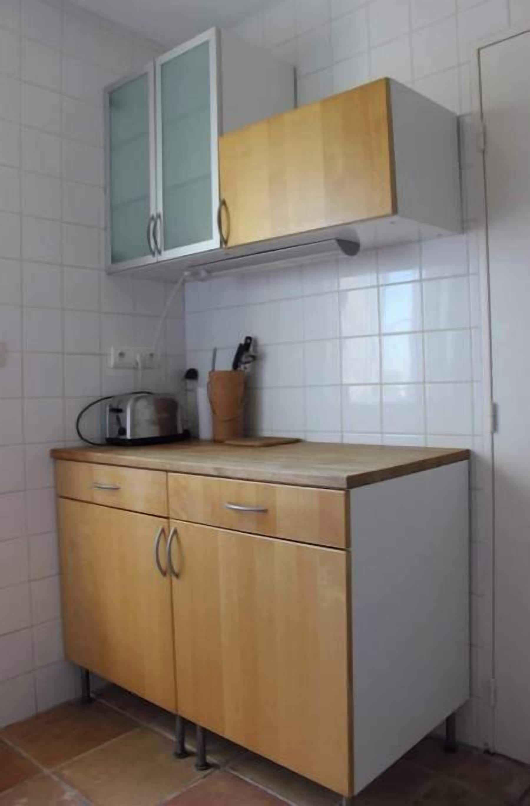 Une cuisine avec un plan de travail en bois, des placards et une fenêtre.