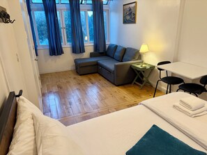 A room with a bed, a sofa, a table, and a chair. - The Willow Residence | En-Suite | Canada Water (London)