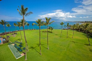 A golf course with a view of the ocean and a pool area with lounge chairs. - Oceanfront 6th Floor - Keawakapu Beach - Pool + AC (Kihei)