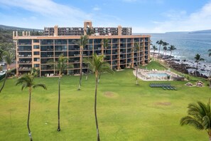 A multi-story hotel with a pool area, palm trees, and a view of the ocean. - Oceanfront 6th Floor - Keawakapu Beach - Pool + AC (Kihei)