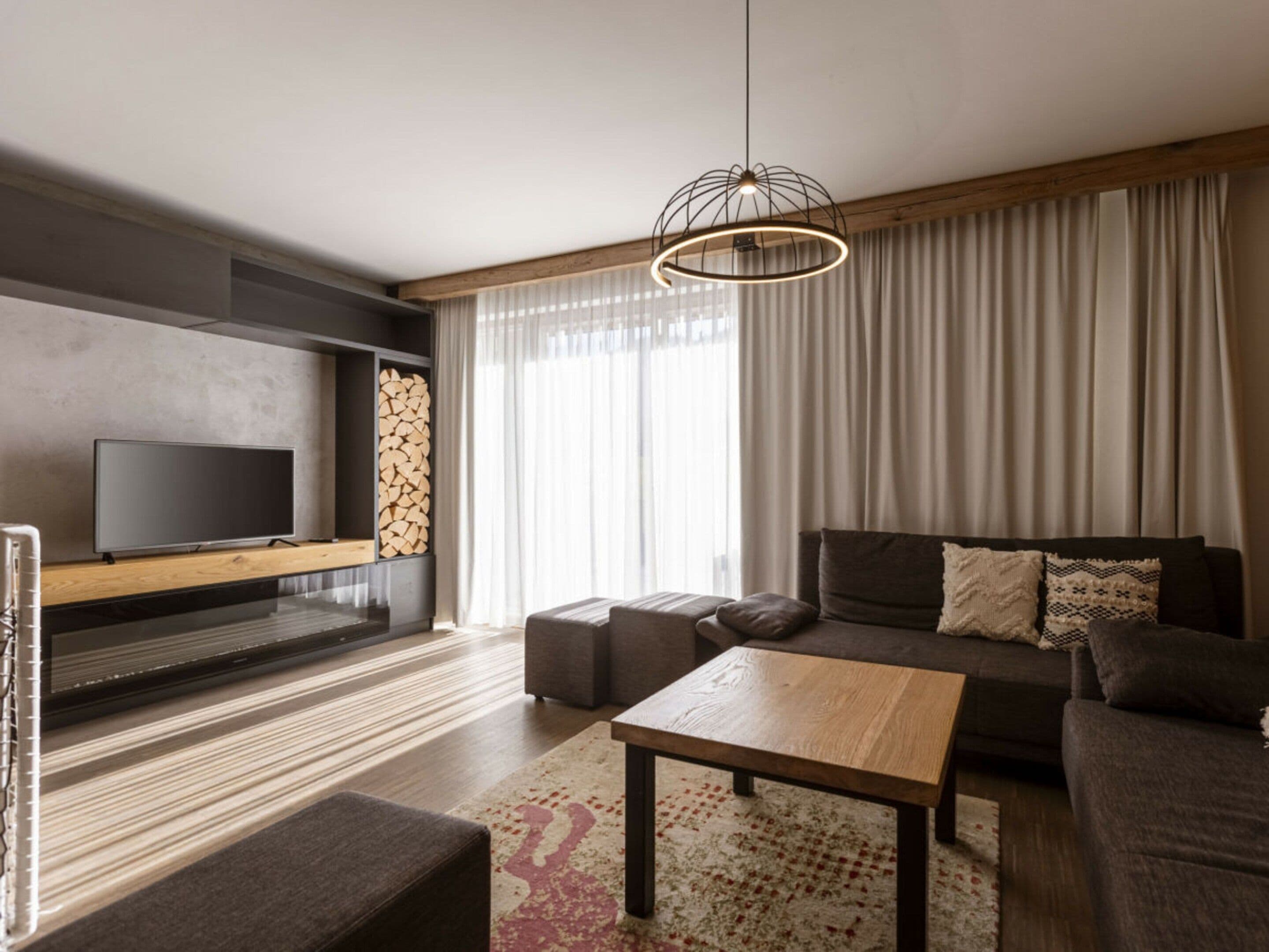 Una sala de estar moderna con una televisión de pantalla plana, un sofá, una mesa de centro y una chimenea.