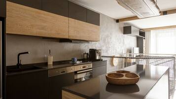 A modern kitchen with a central island, built-in appliances, and a large window providing natural light.