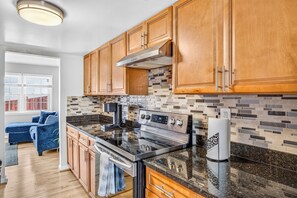 A modern kitchen with wooden cabinets, a stainless steel range, and a tiled backsplash. - Near Quantico & DC spacious, comfortable in quite area Laundry included Sleeps 6 (Woodbridge)