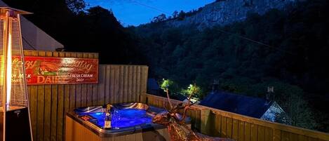 A hot tub with a deer head decoration, surrounded by wooden deck and a sign for a dairy product.