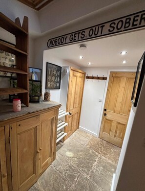 Eine Küche mit Holzausstattung, einer Arbeitsplatte und einem Schild an der Decke mit der Aufschrift 'NOBODY GETS OUT SOBER'.