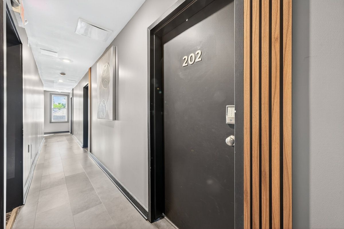 A hallway with a door labeled '202' and a window at the end.