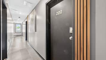 A hallway with a door labeled '202' and a window at the end.