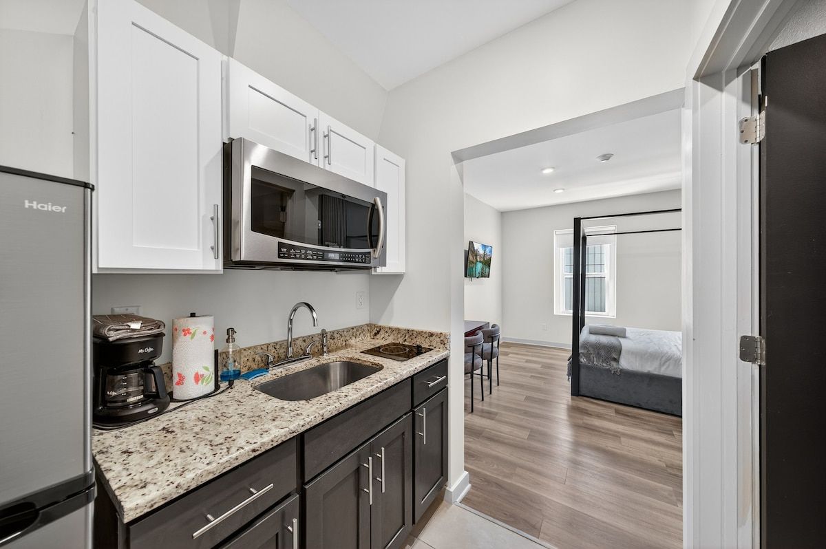 A modern kitchen with a stainless steel refrigerator, a microwave, and a coffee maker.