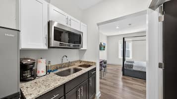 A modern kitchen with a stainless steel refrigerator, a microwave, and a coffee maker.