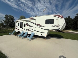 Un camping-car Laredo doté d’un espace abrité et de chaises bleues.