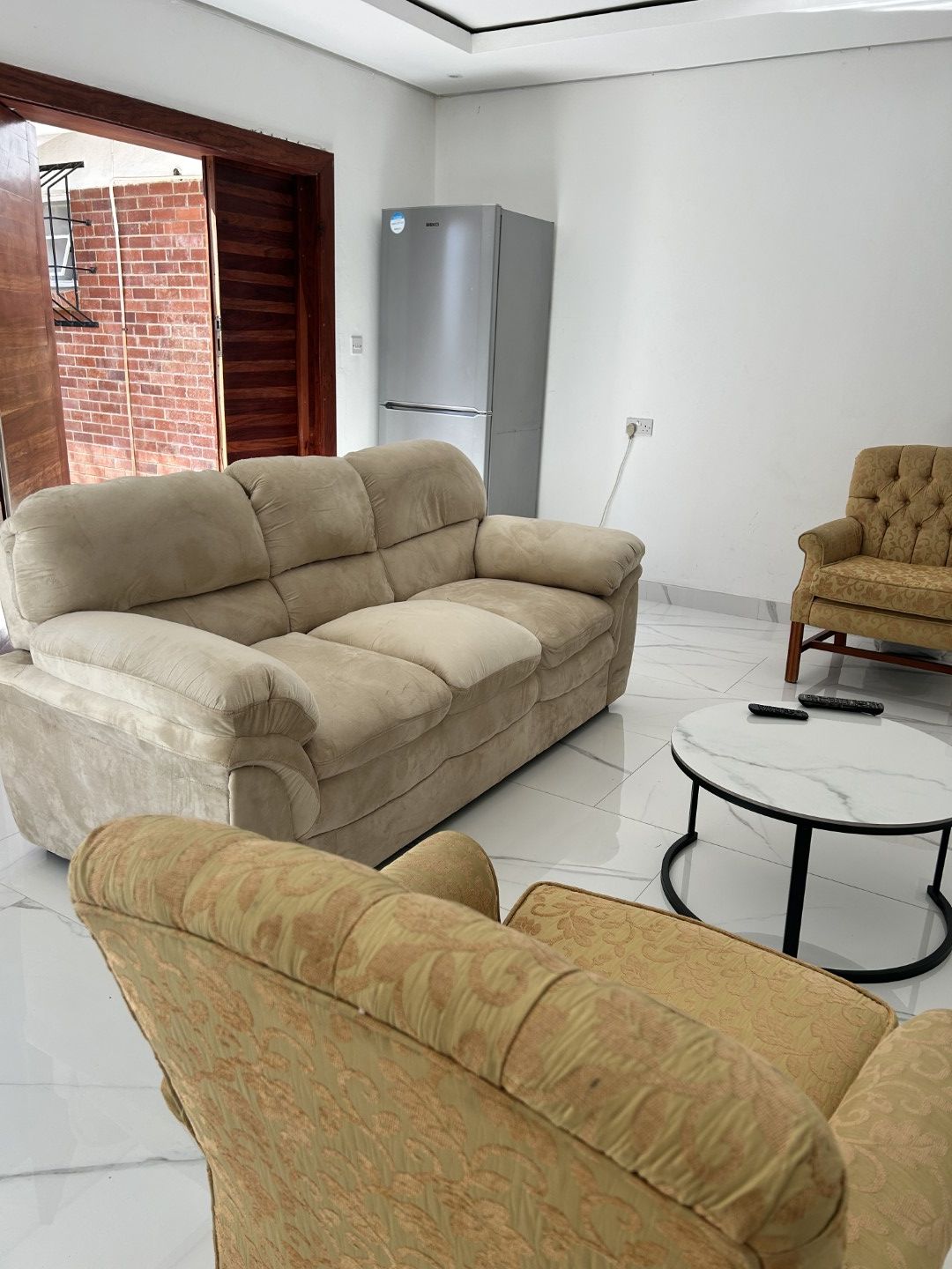 A living room with a sofa, armchair, and a small round table.