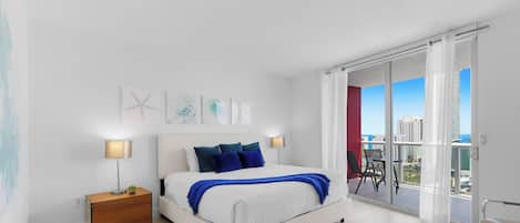 Une chambre moderne avec un lit, des tables de chevet, des œuvres d’art et un balcon offrant une vue sur la ville.