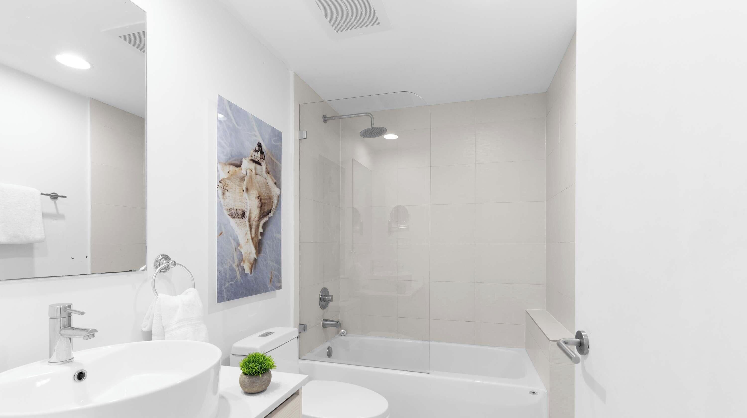 Een moderne badkamer met een bad, een wastafel en een douche.