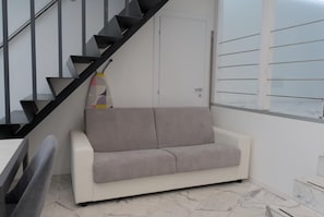 Ein modernes Interieur mit einer Treppe, einem Sofa und einem Fenster.