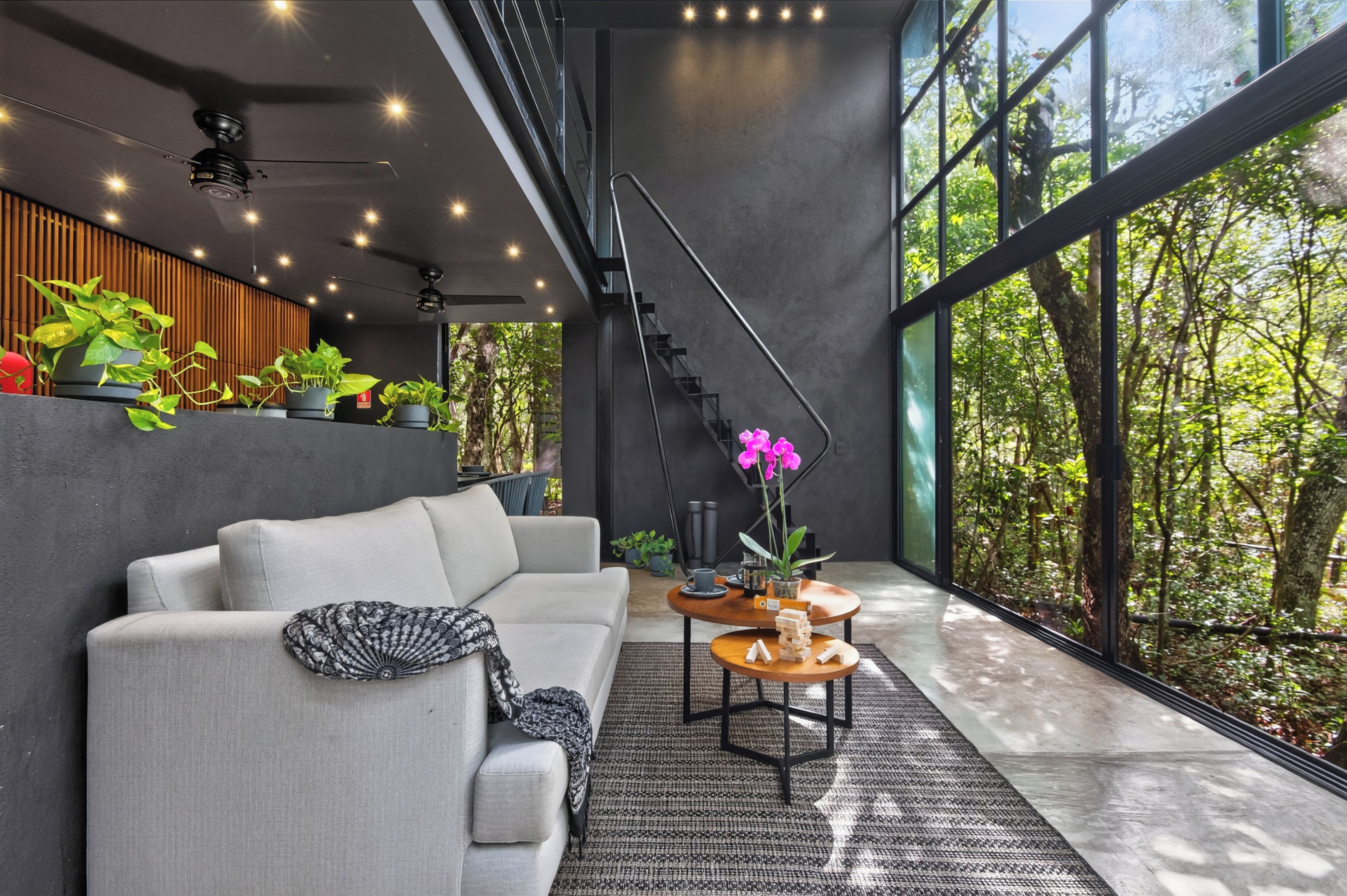 Un interior moderno con un sofá, una mesa de centro y plantas.