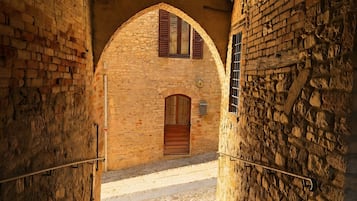 Ein Steinhaus mit Bogenportal und Holztür.