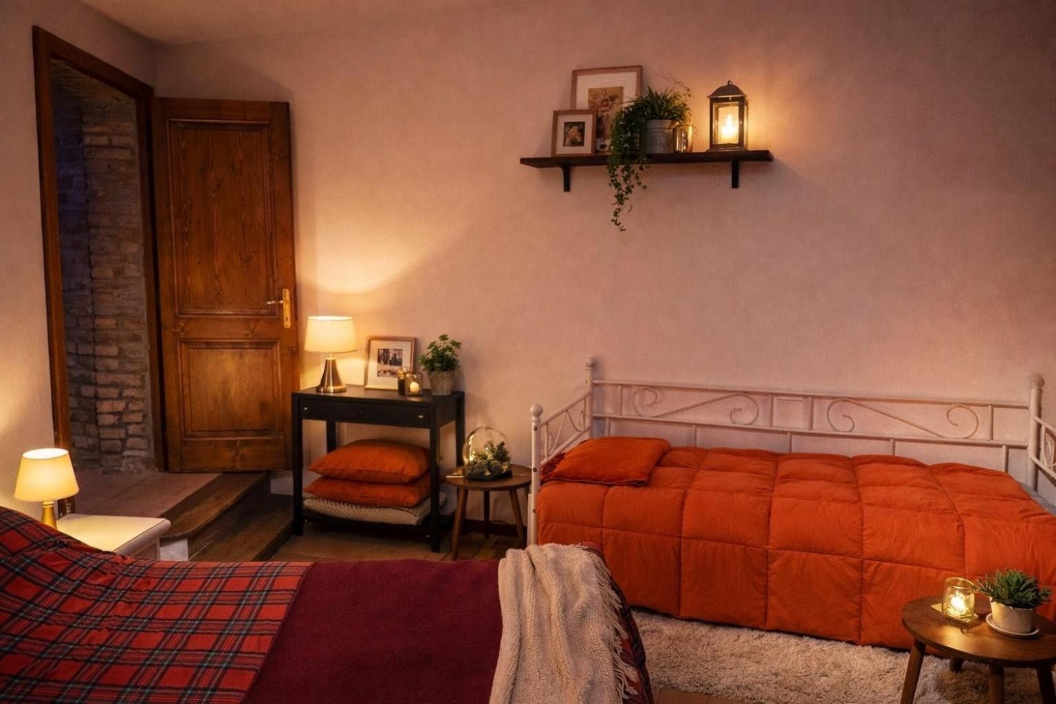 Una camera accogliente con un letto, un comodino, una lampada e uno scaffale con oggetti decorativi.