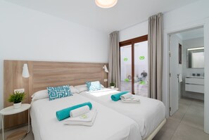 Een hotelkamer met een tweepersoonsbed, een nachtkastje, een kleine potplant en uitzicht naar buiten.