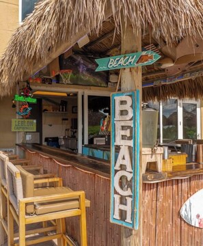 A beach-themed bar with a wooden counter and a sign indicating 'BEACH'.