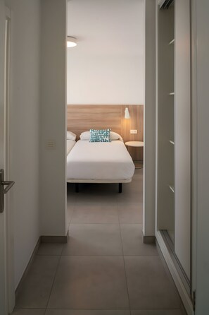 Een hotelkamer met een bed, nachtkastje en een lamp.