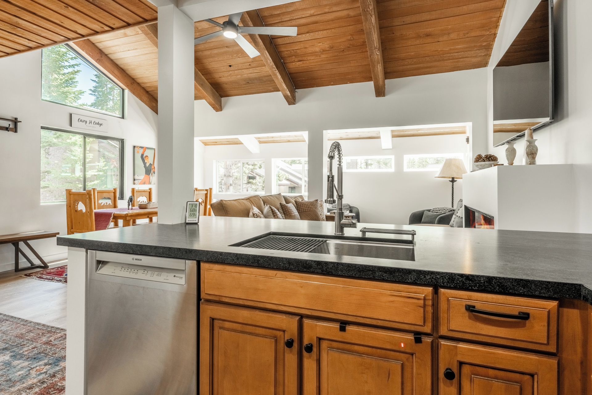 A modern kitchen with wooden cabinets, a stainless steel sink, and a Bosch dishwasher.