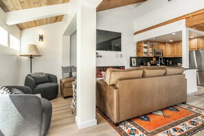 A modern living room with a sofa, a coffee table, and a fireplace. - Newly Remodeled Walk to Ski Condo 615 (Mammoth Lakes)