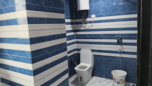 Un baño con un inodoro, un bidé y un cubo.