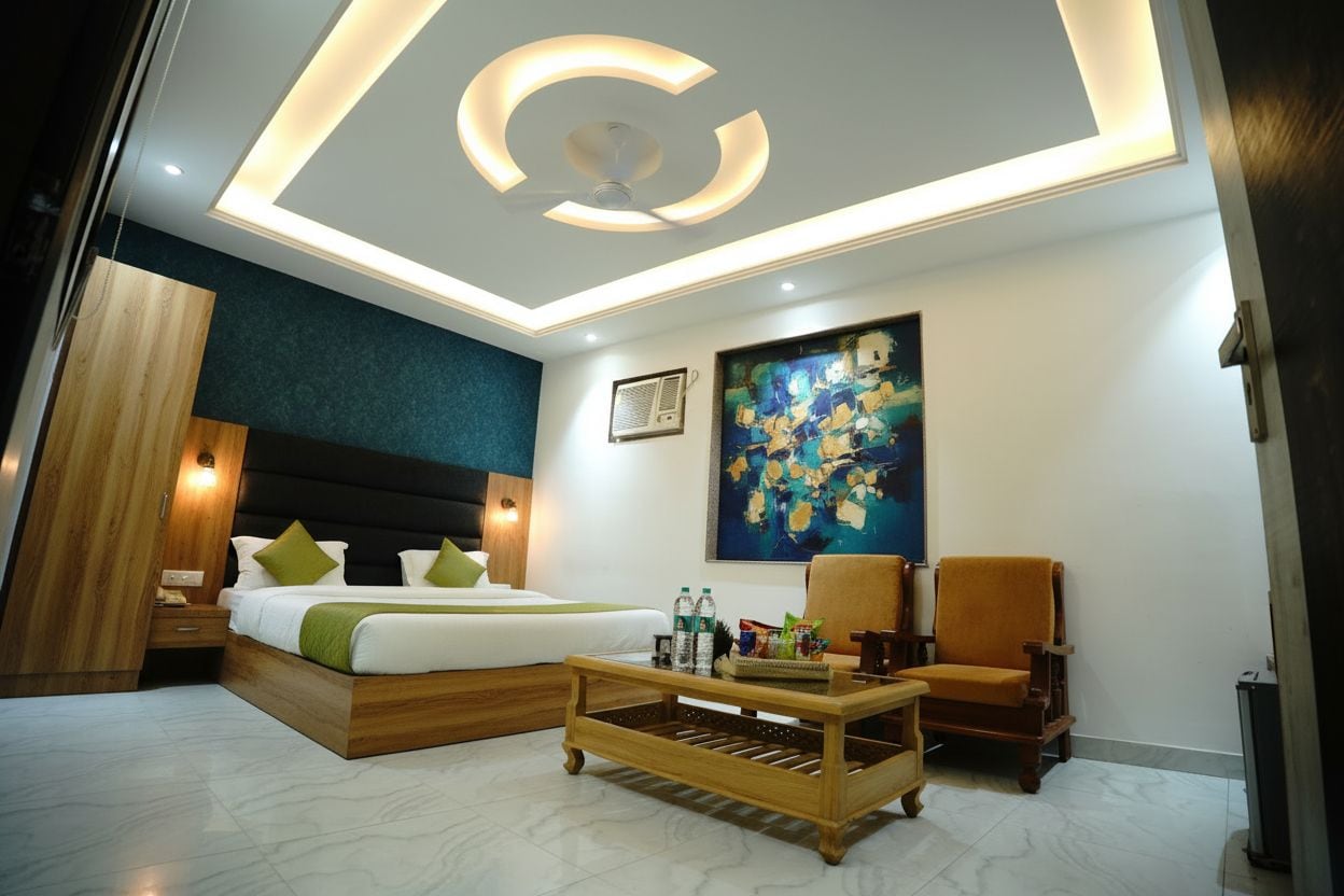 A modern hotel room with a bed, a coffee table, a chair, and a painting on the wall.