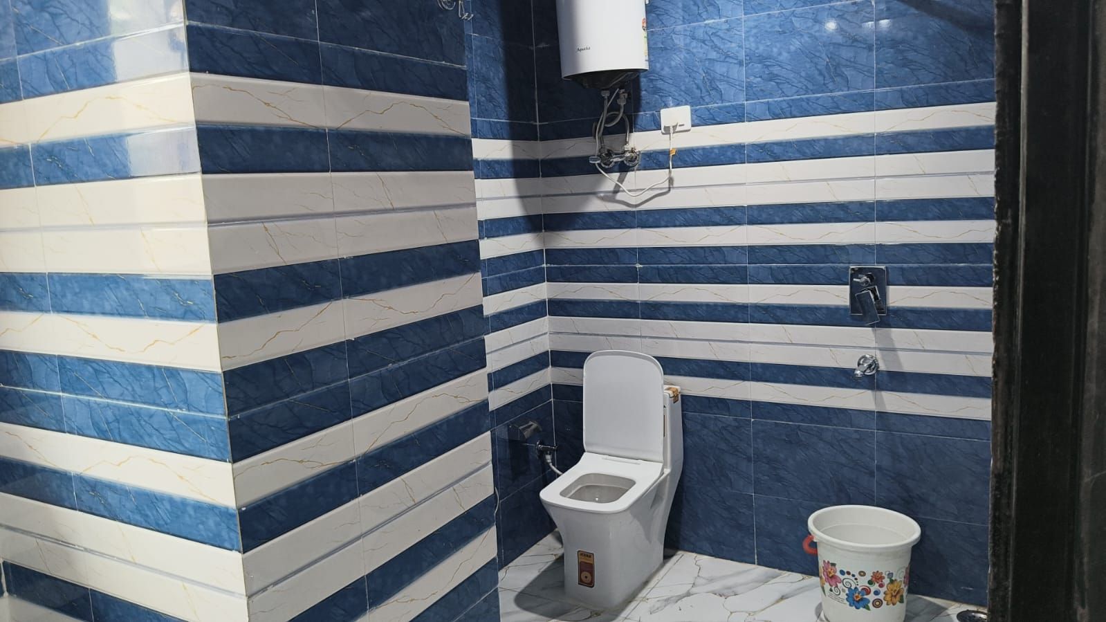 Un baño con un inodoro, un bidé y un cubo.