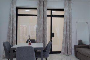 Uma sala de conferências com mesa, cadeiras, quadro branco e sofá.