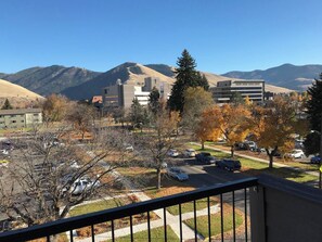 A residential area with a parking lot, buildings, and mountains in the background. - Modern Apt a Block from St. Pat's Hospital #202 (Missoula)