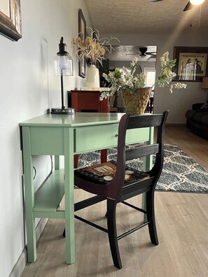 A dining area with a green table, a dark wooden chair, and a vase with flowers. - River Living One Story 2bd/2ba - On the River - 2 Blks to Main St - VIEWS GALORE (Madison)