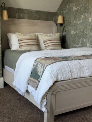 Ein Bett mit Kopfteil, Kissen und Decke.
