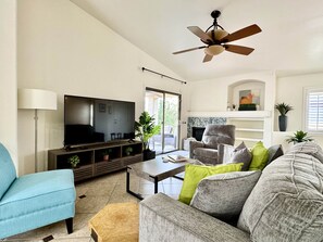 A living room with a television, sofa, armchair, and a ceiling fan. - Dove Mountain #12361 (Marana)