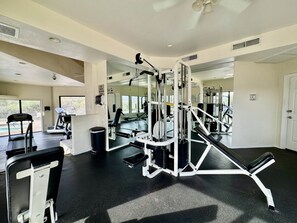 A gym with exercise equipment, a treadmill, and a mirror wall. - Greens at Ventana Canyon #13104 (Catalina Foothills)