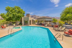 A swimming pool with lounge chairs and a barbecue area, surrounded by trees and mountains in the background. - Greens at Ventana Canyon #13104 (Catalina Foothills)