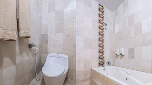 A bathroom with a toilet, a bathtub, and a tiled shower wall. - Collection O Near AEON Mall 96 Boutique (Melaka)