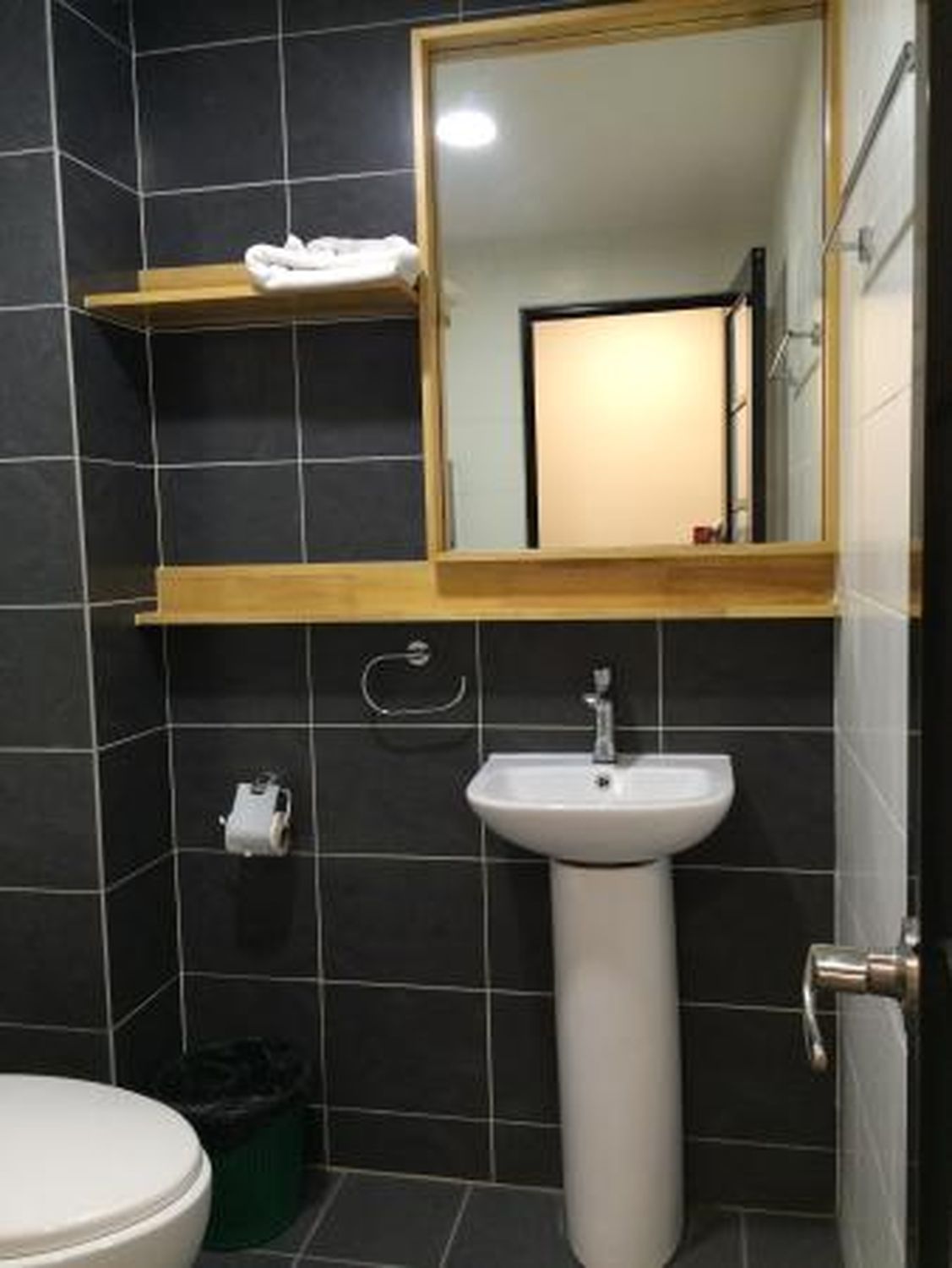 Un baño con un lavabo blanco, un espejo y un inodoro.