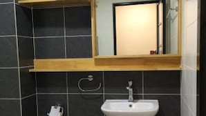 A bathroom with a white sink, a mirror, a towel rack, and a toilet.