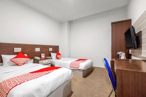 A hotel room with two beds, a desk, a television, and a minibar. - Collection O Near AEON Mall 96 Boutique (Melaka)