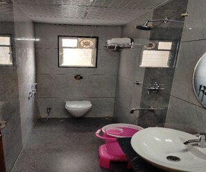 Ein kleines, kompaktes Badezimmer mit Toilette, Waschbecken und Duschbereich.