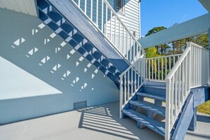 A staircase with a geometric pattern on the wall, leading to a white railing.