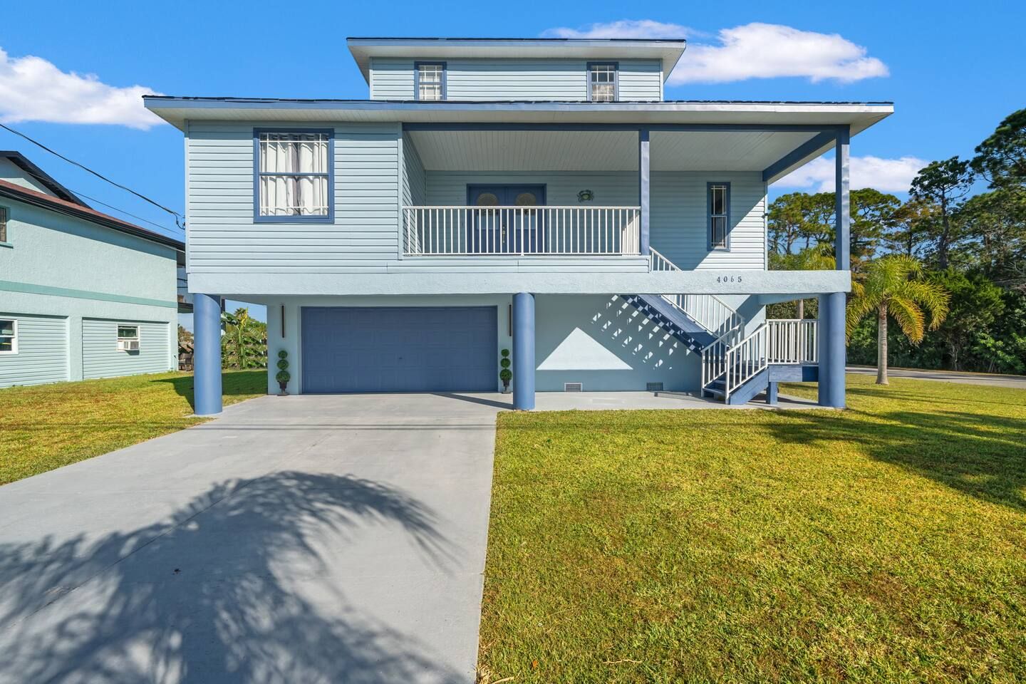 A two-story house with a garage, a balcony, and a staircase leading to the upper floor.
