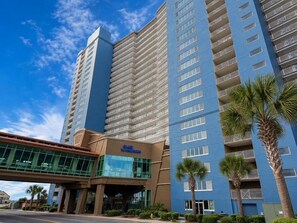 Ein Hotel mit modernem Design, das eine auffällige Glasfassade und eine blaue Außenwand besitzt.
