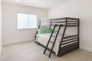A bunk bed with a ladder, a window with blinds, and a light-colored floor. - 3BR Cozy and Clean House near Beach and Disney (Garden Grove)