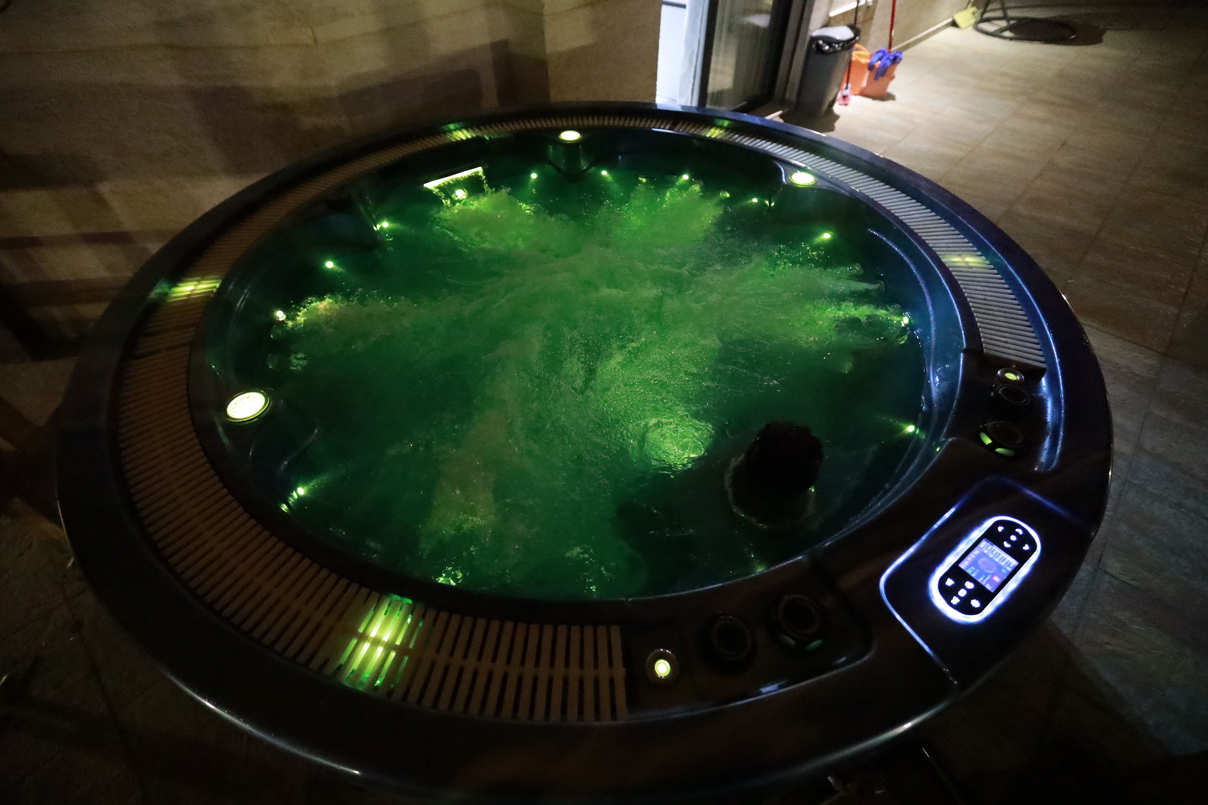 Un jacuzzi con panel de control digital y piso de baldosas.