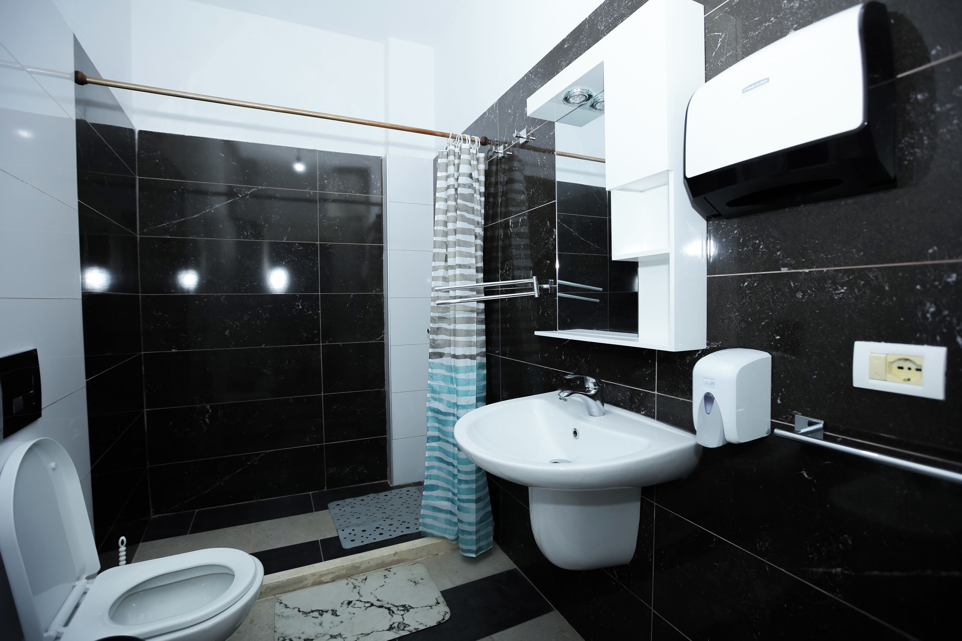 Ein modernes Badezimmer mit Toilette, Waschbecken und Dusche.