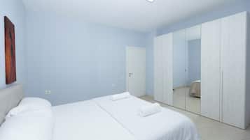 Ein Schlafzimmer mit einem Bett, einem Kleiderschrank und einem Spiegel.