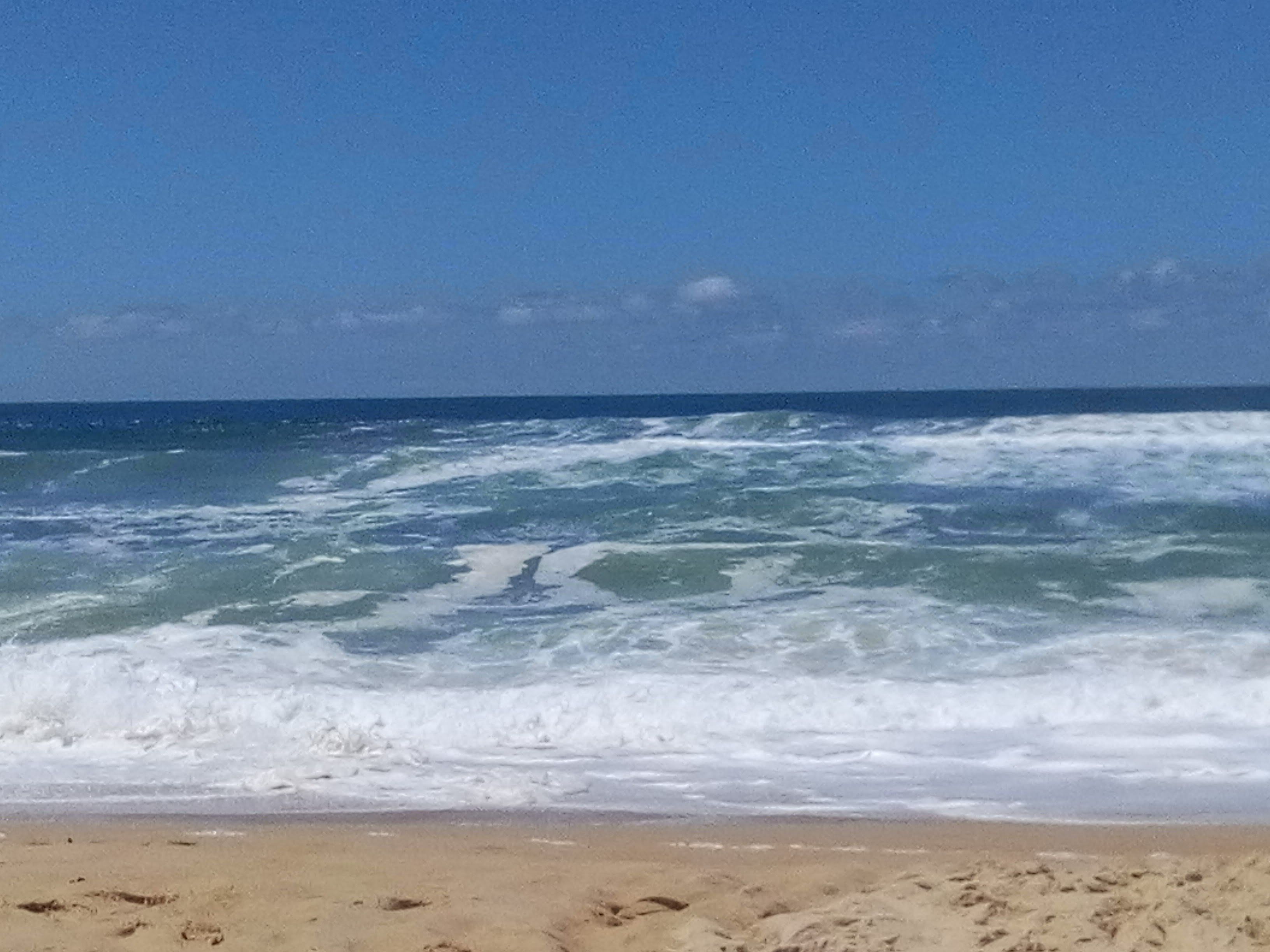 A beach with waves crashing onto the shore.